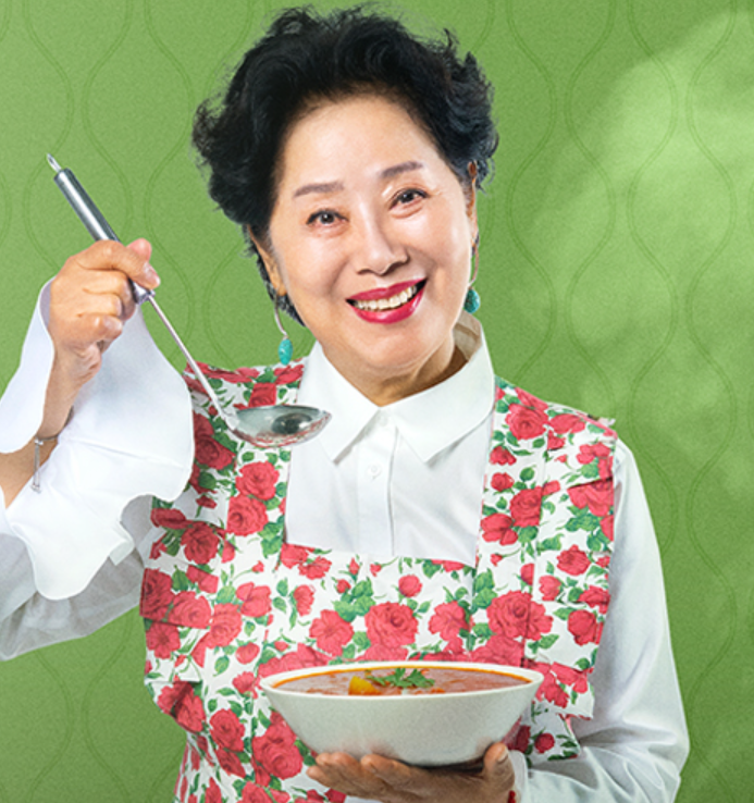 요리하는 용여, 한끼 재방송 홍보 이미지. 꽃무늬 앞치마를 입고 수프를 들고 웃고 있다.